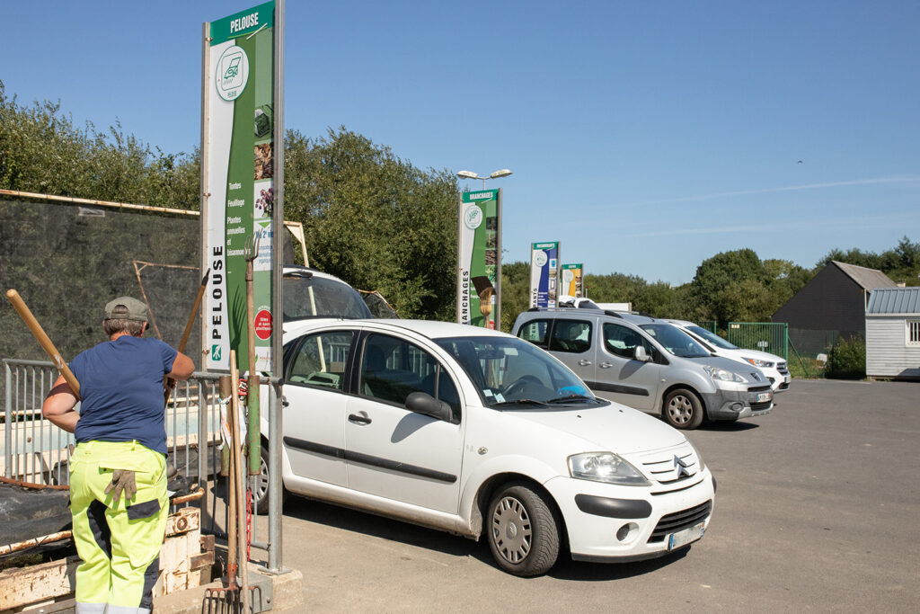 Voiture devant une benne en déchèterie